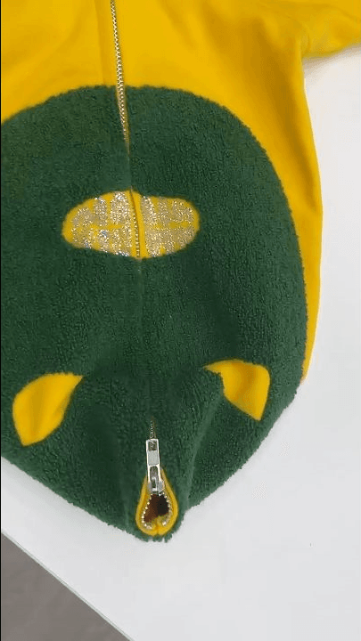Textured raised green decoration on a yellow zip garment for technique comparison