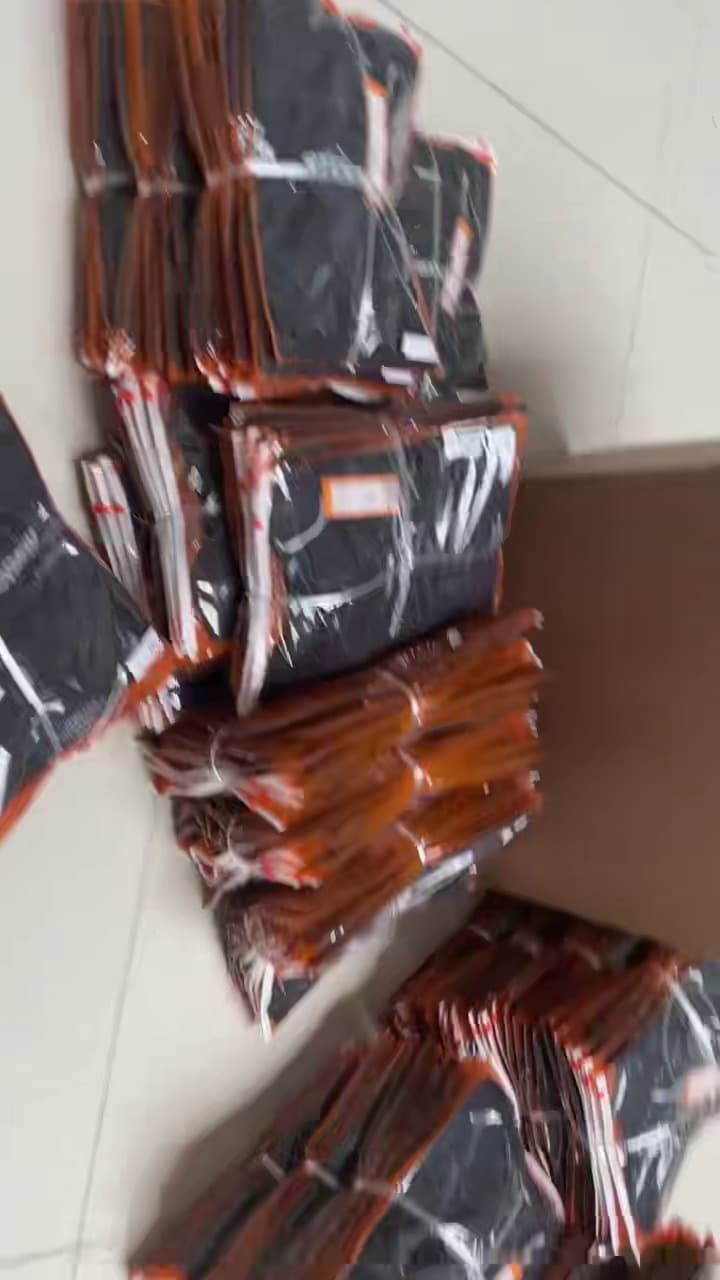 Polybagged garments stacked next to open shipping cartons at Meiting Garments packing area