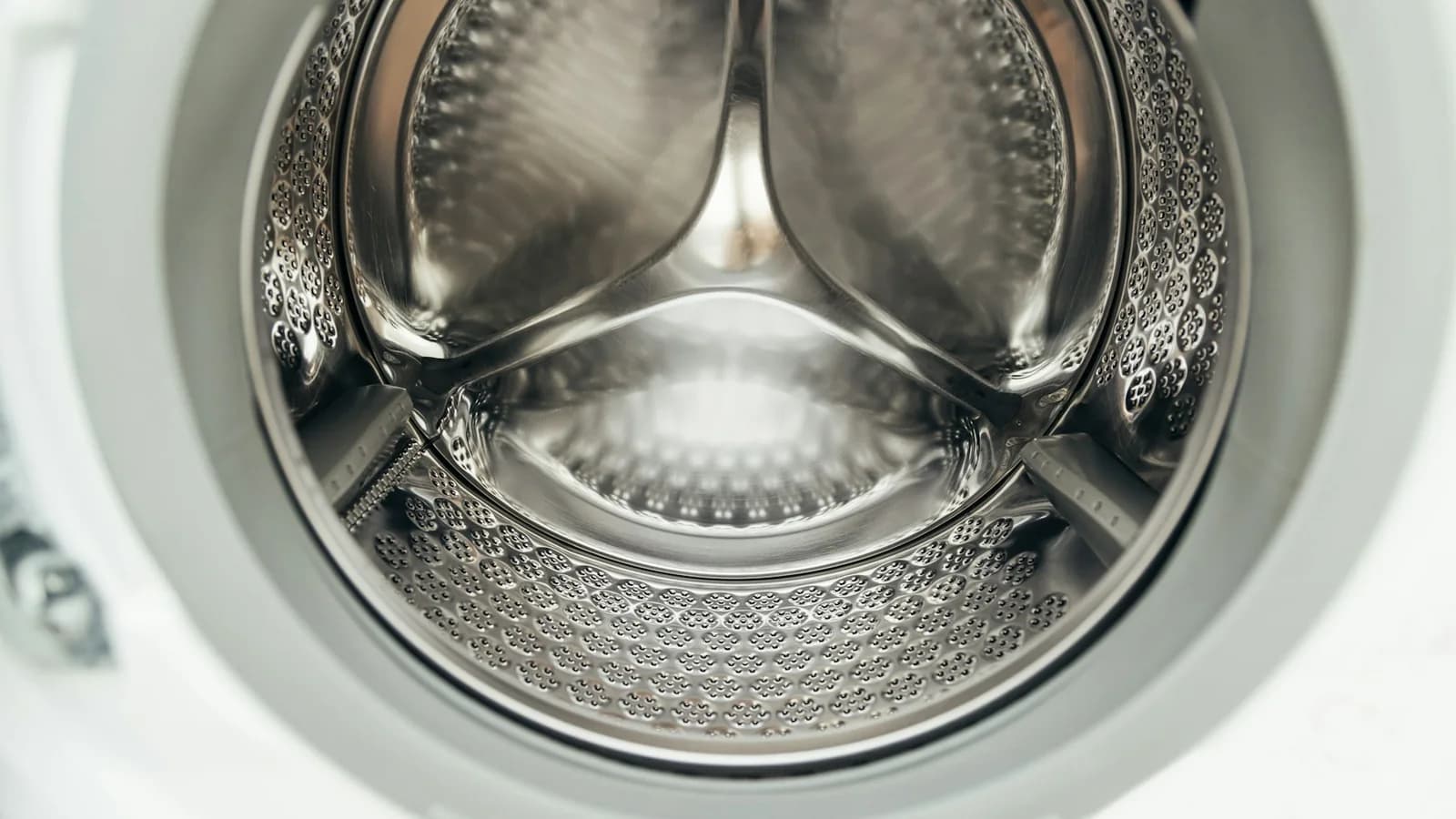 Clean empty stainless-steel washing machine drum filling the frame