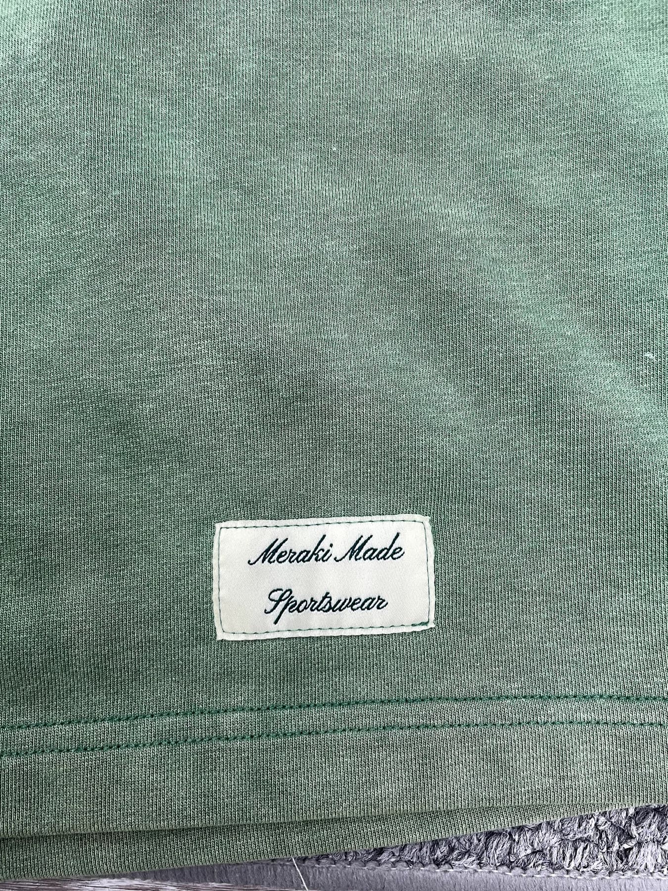 Green garment-dyed jersey surface with label and seam detail