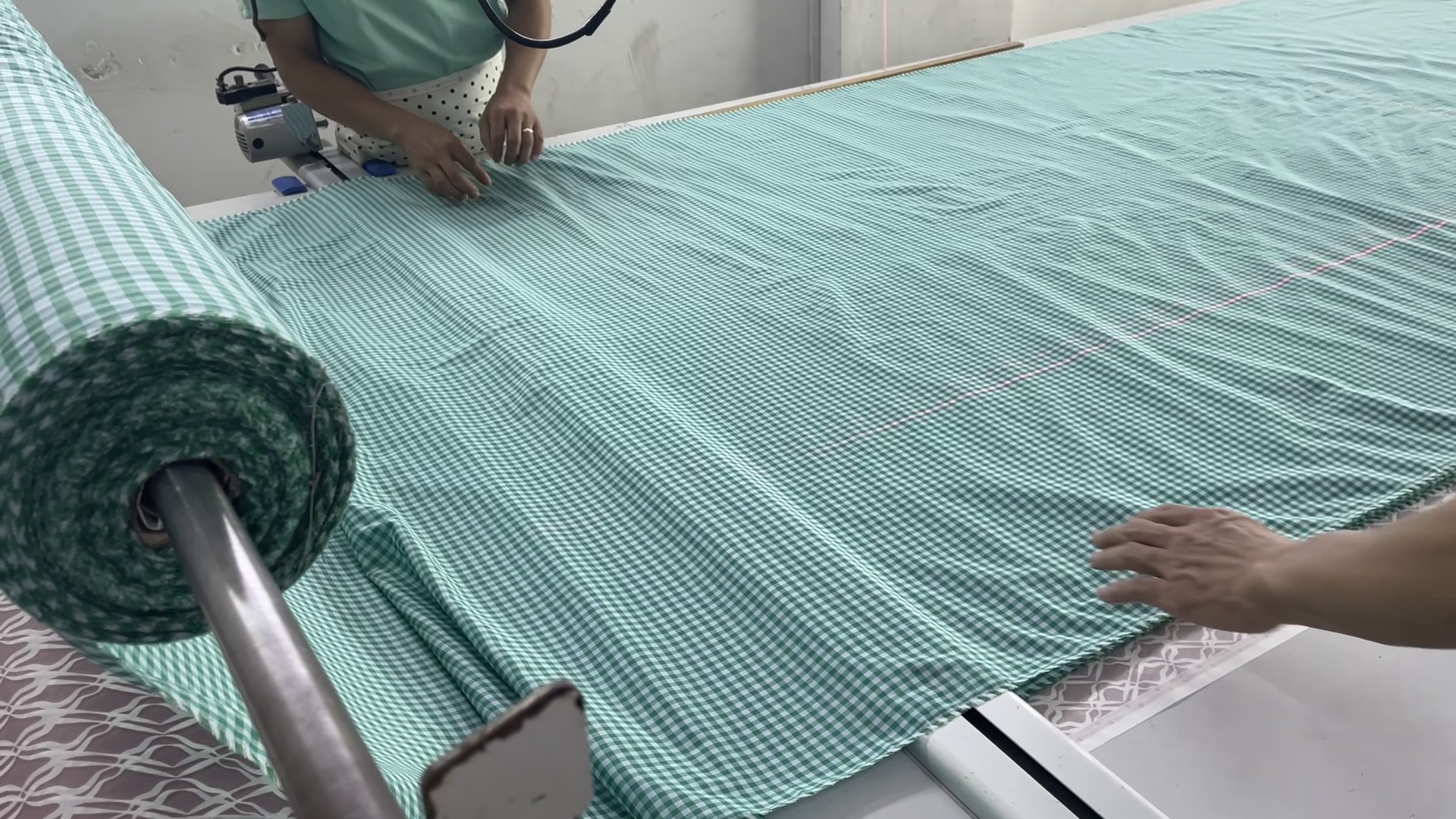 Fabric roll being spread on the cutting table at Meiting Garments before bulk cutting